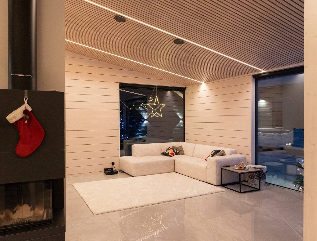 La hauteur du salon est supérieure à 3 mètres et la bande LED suffit à éclairer l'espace. Le ruban est réglable en fonction de la température de la couleur Le ruban a une lumière blanche chaude qui met en valeur le ton naturel du bois.